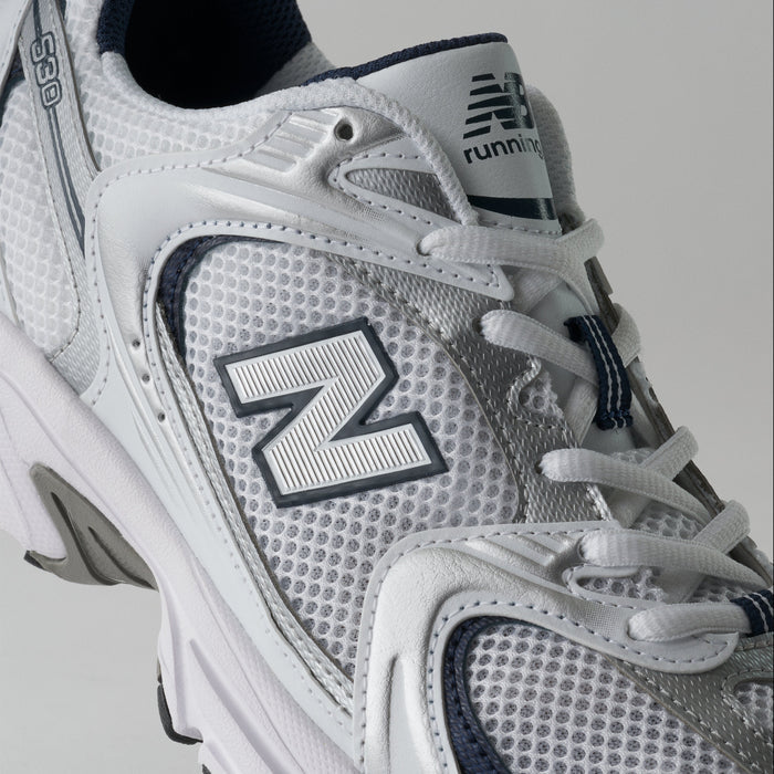 Gray running shoe with New Balance logo on a light gray background