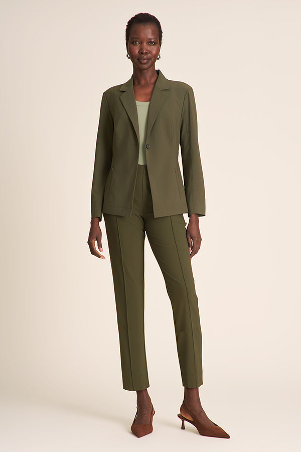 Woman wearing a green suit on a beige background | Exclude