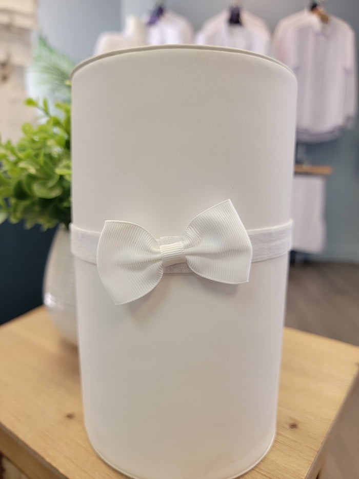 Small white bow on elastic headband.
