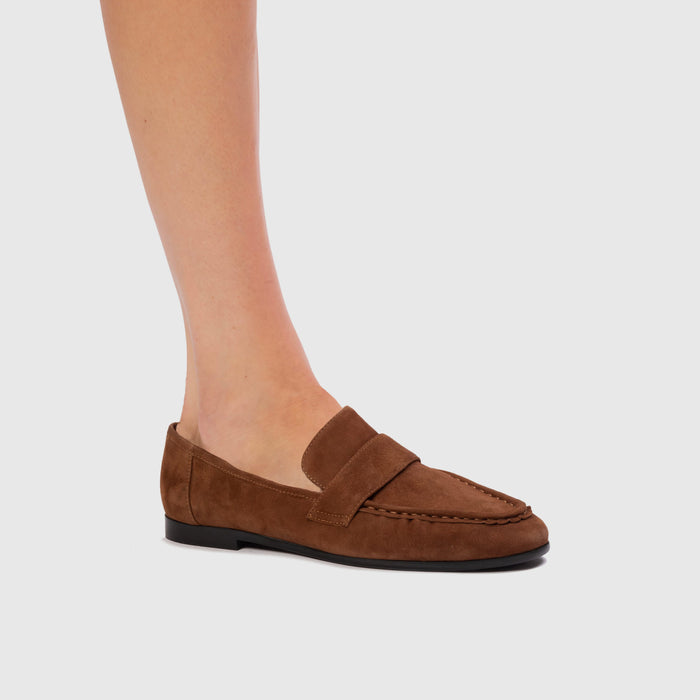 Brown loafer shoe on a light gray background