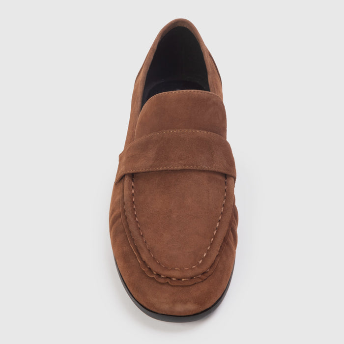 Brown loafer shoe on a light gray background