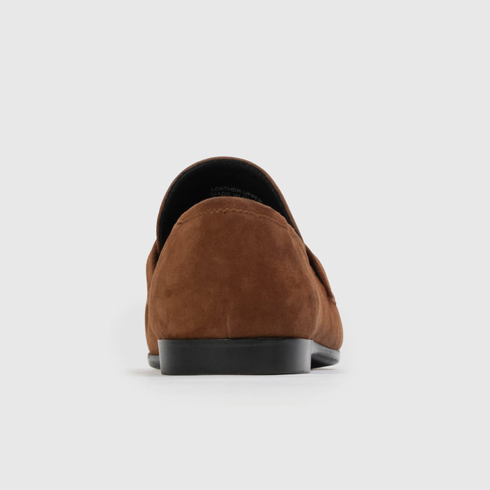 Brown suede loafer on a light gray background