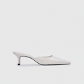 White high-heeled shoe on a light gray background | Lead