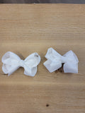 Two small white ribbon bow hair clips.