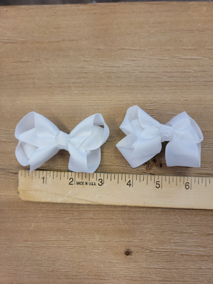Two small white ribbon bow hair clips.