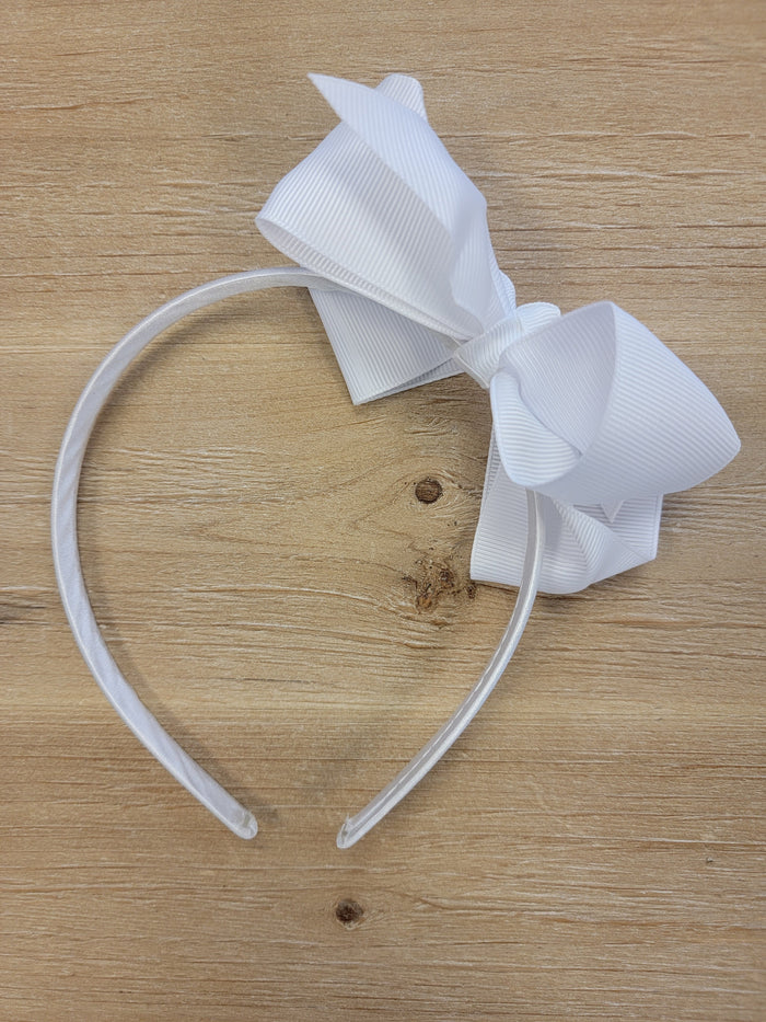 White ribbon bow on thin white headband.