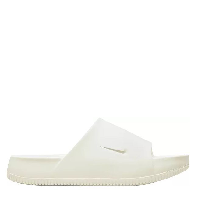 A pair of white Nike Kawa slides for men and women with a contoured design and textured footbed.