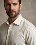Man wearing a light-colored shirt against a neutral background