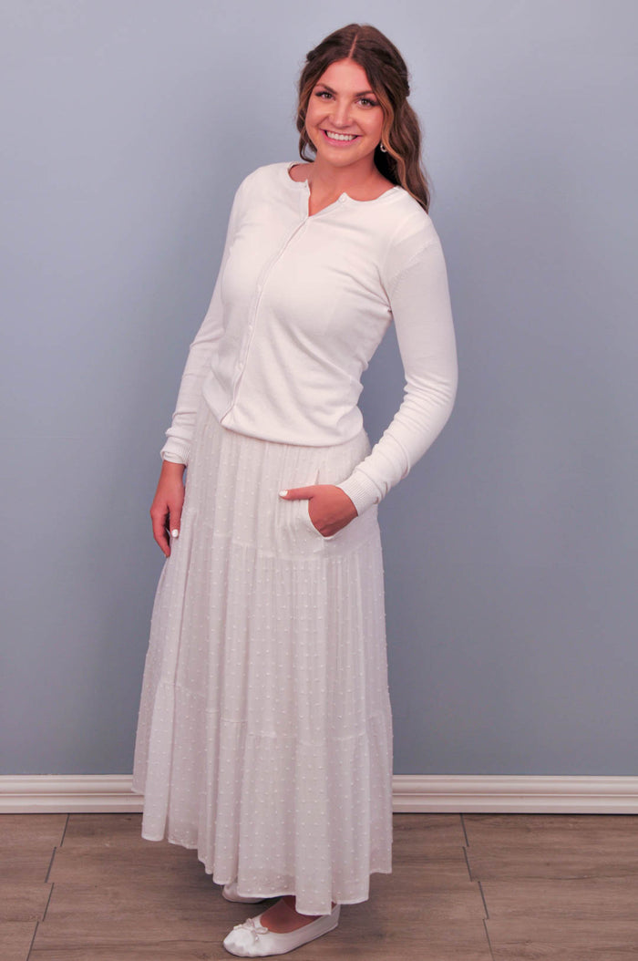 White crew neck button up cardigan on model.