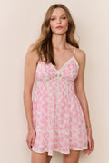 Woman wearing a pink heart dress against a plain background
