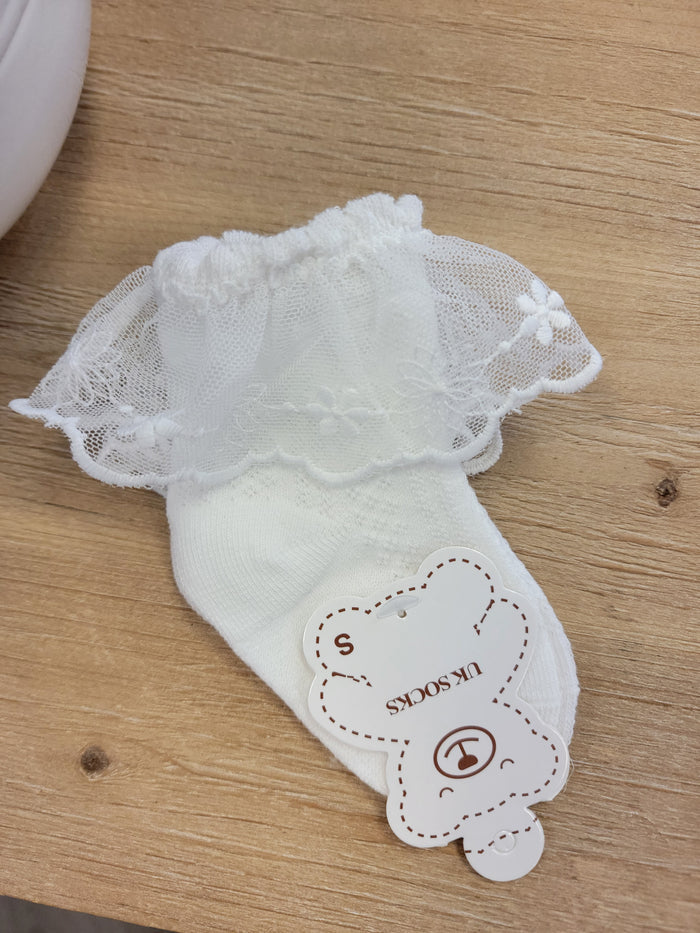 Baby sock with lace ruffles.