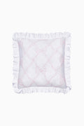 White pillow with ruffled edges and pink embroidery on a white background