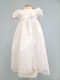 White baby gown with floral embroidery.