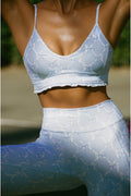 Person wearing a light blue sports bra and leggings with a geometric pattern.