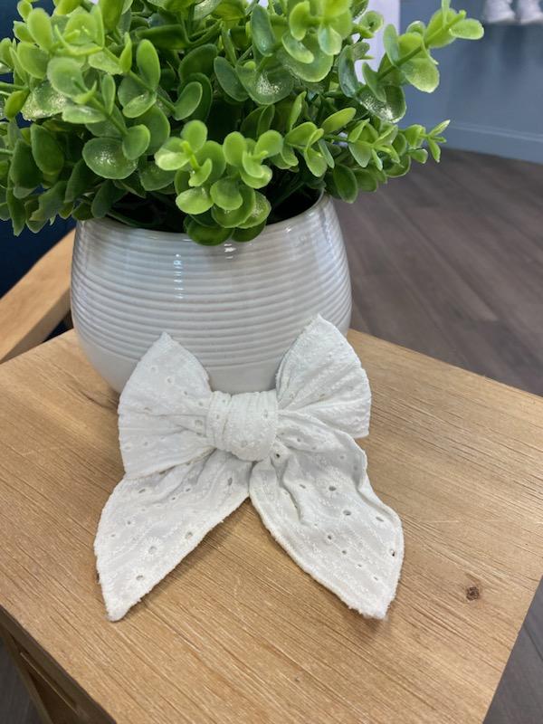 Bow hair clip made of white eyelet lace.