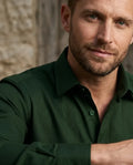 Man wearing a green shirt with a neutral background