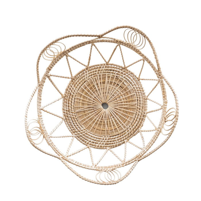 A round natural rattan serving tray with a boho design, featuring raised edges and a woven pattern.