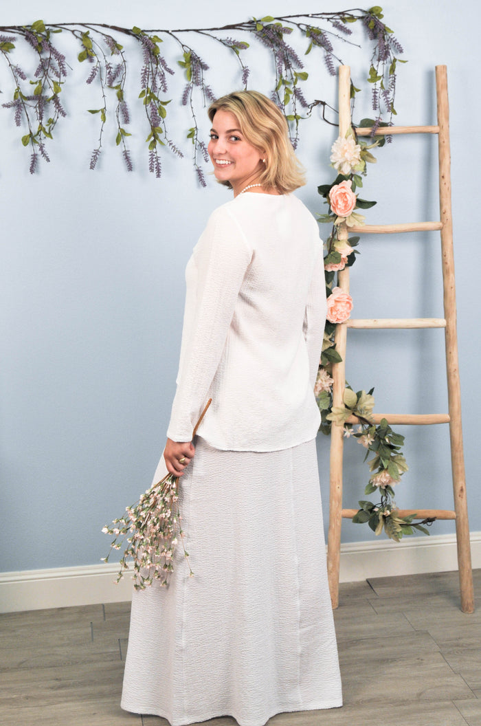 side profile of woman in skirt and blouse