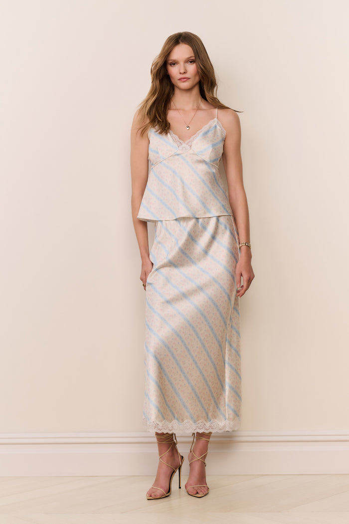 Woman wearing a striped dress against a plain background