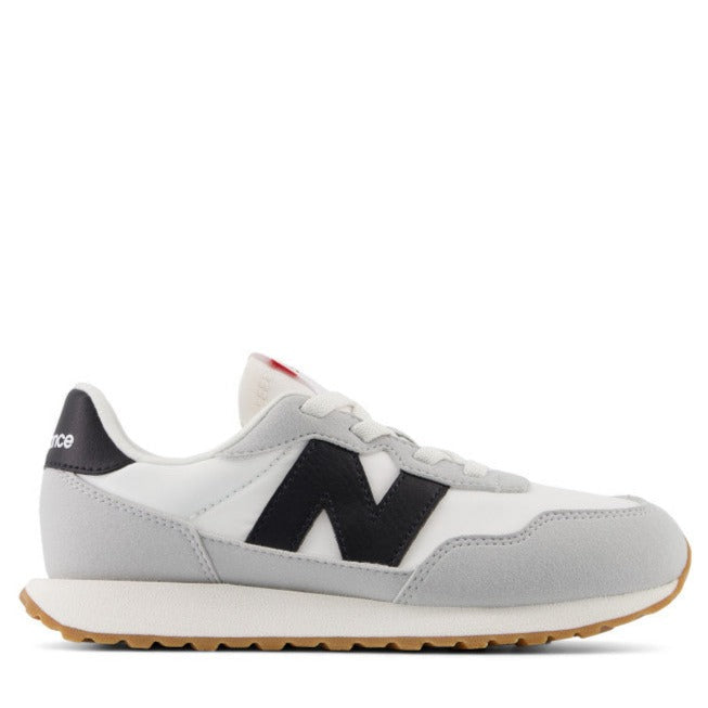 A pair of New Balance Kids' 237 athletic shoes with a combination of suede and nylon upper in gray color, featuring a durable rubber outsole and a breathable mesh lining.