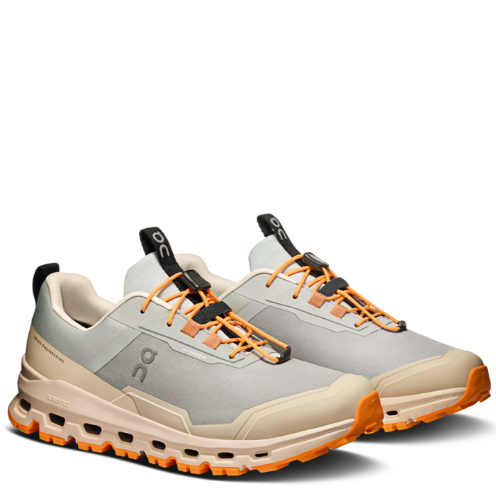 A pair of kids' waterproof running shoes with a beige upper, black and orange details, and a gray sole.