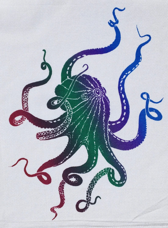 A colorful kitchen towel featuring a handscreened octopus design with tentacles in various colors on a white background.