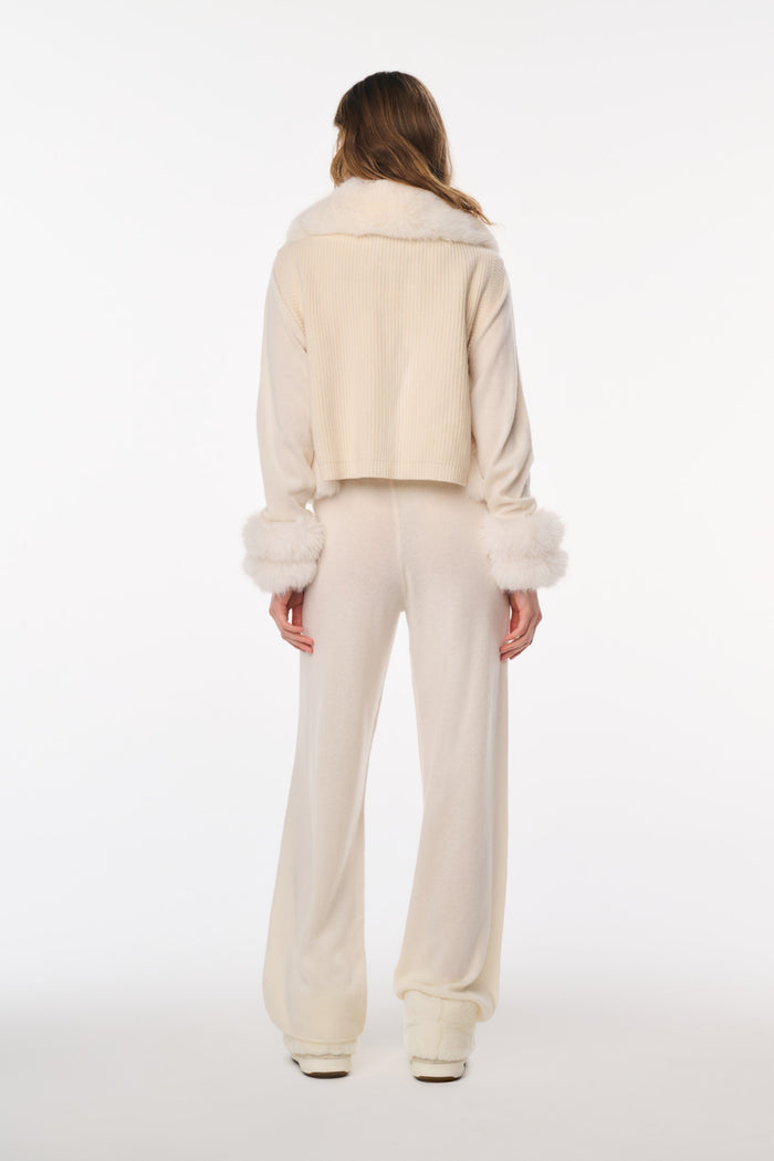 Person wearing a cream-colored outfit on a white background