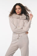 Woman wearing a light gray hoodie and pants set on a white background