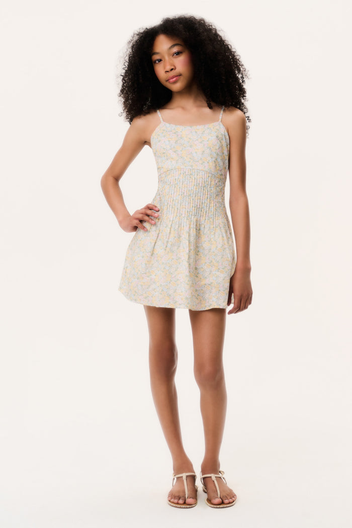 Young girl wearing a white floral dress on a white background