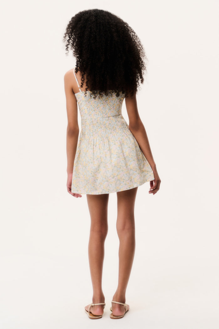 Girl wearing a floral mini dress on a white background