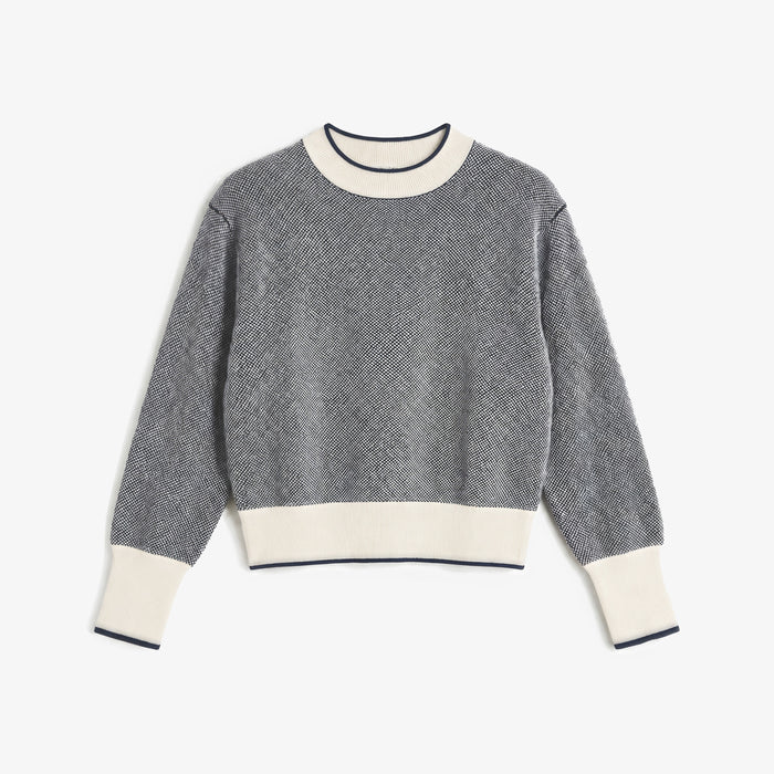 A gray and white textured knit crewneck sweater with cream ribbed collar, cuffs, and hem, displayed flat against a light gray background. | Lead