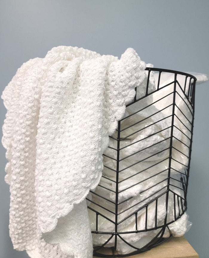 Popcorn knit baby blanket in basket.