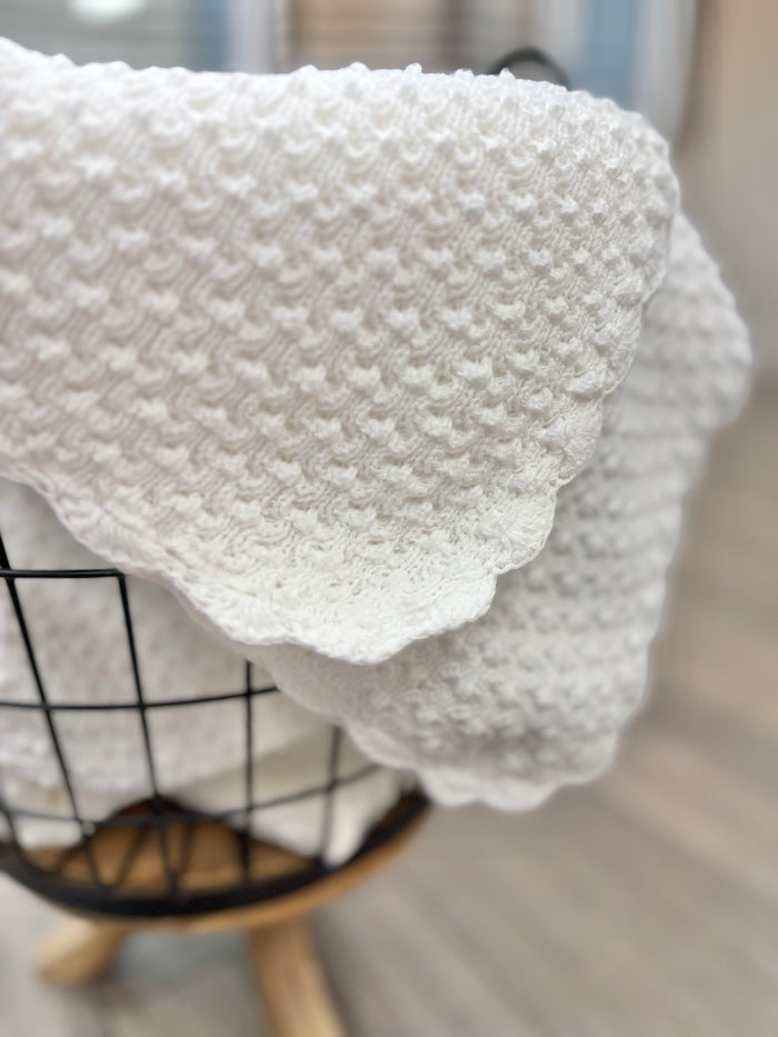 Popcorn knit baby blanket in basket.