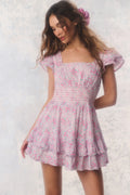 Woman wearing a pink floral dress against a light background