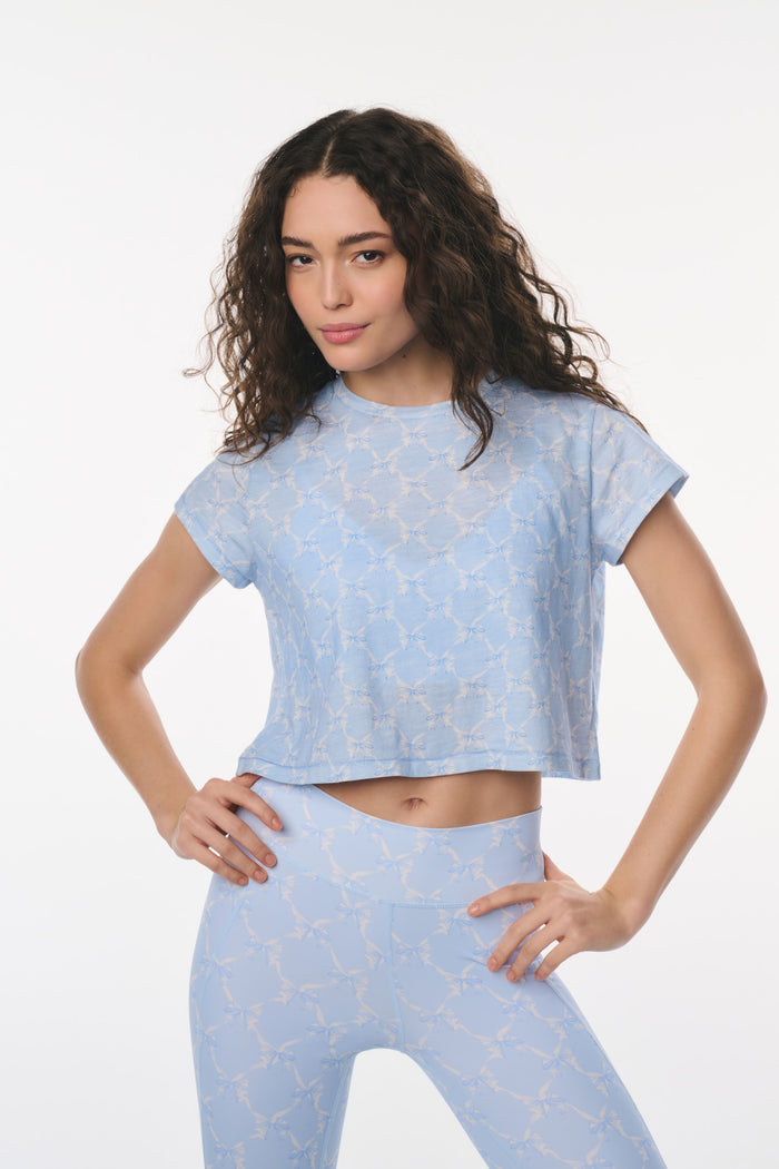 Woman wearing a light blue athletic outfit on a white background