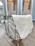 White knit baby blanket in basket.