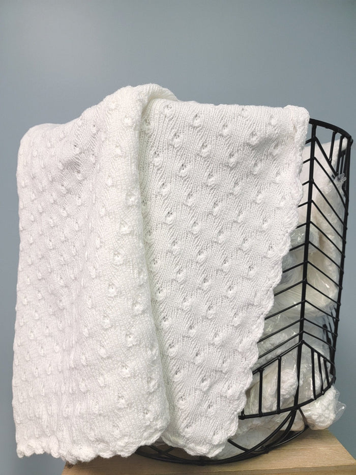 White knit baby blanket in basket.
