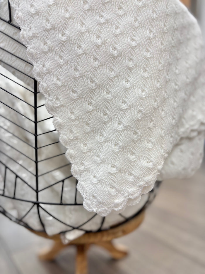 White knit baby blanket in basket.