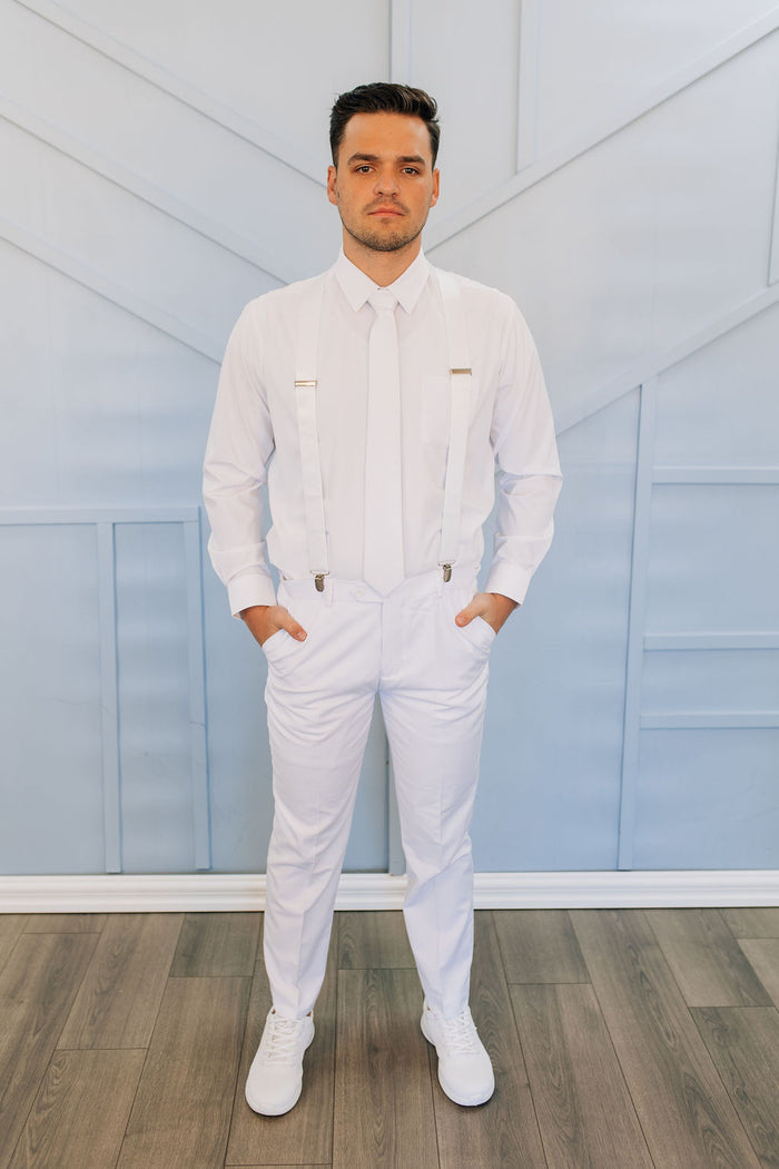 Man in all white pants, button up shirt, tie, and suspenders.