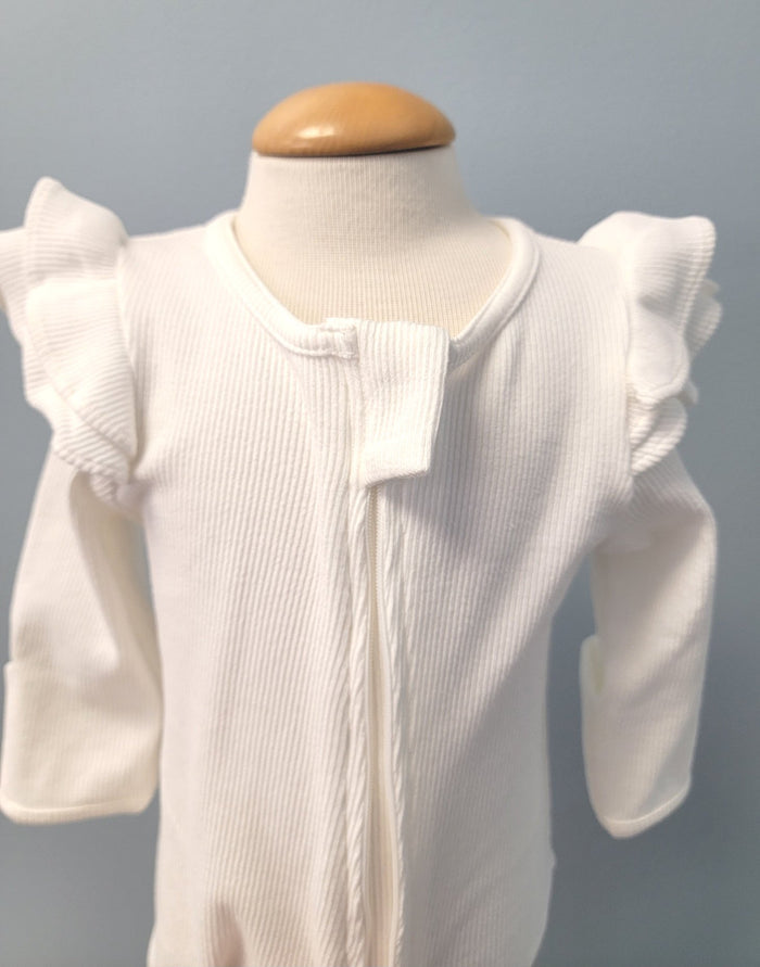 White baby romper with zip front and ruffles.