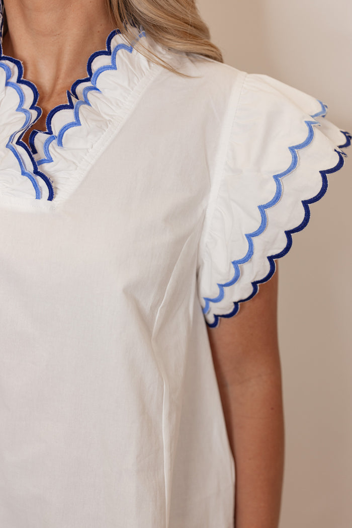 Women's summer off white poplin top with blue and navy scalloped trim by Umgee showing sleeve detailing
