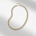 A gold chain necklace with elongated oval links and a short extender chain with a clasp, displayed on a light gray background. | Lead