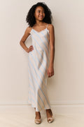 Girl wears Striped slip dress with thin straps on beige background