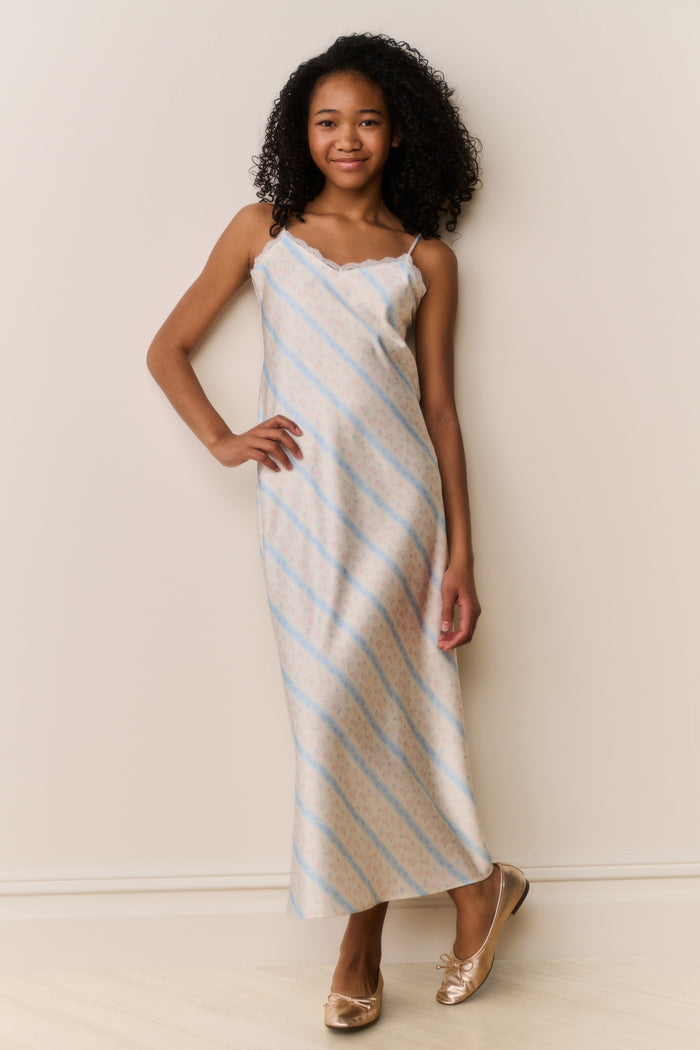 Girl wears Striped slip dress with thin straps on beige background