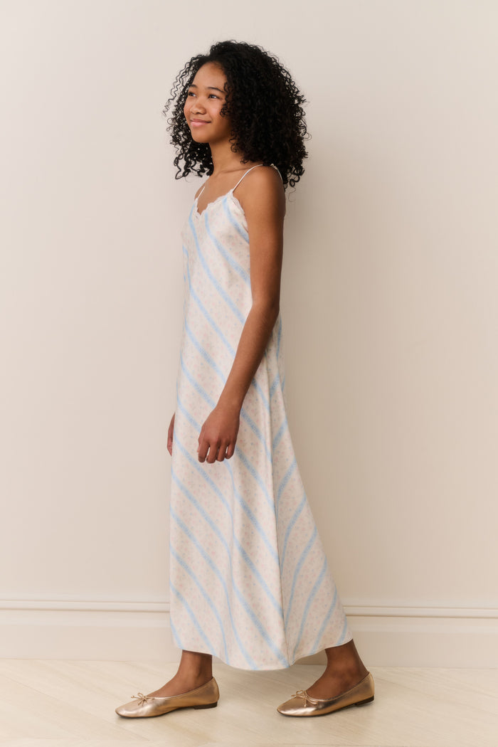 Girl wears Striped slip dress with thin straps on beige background