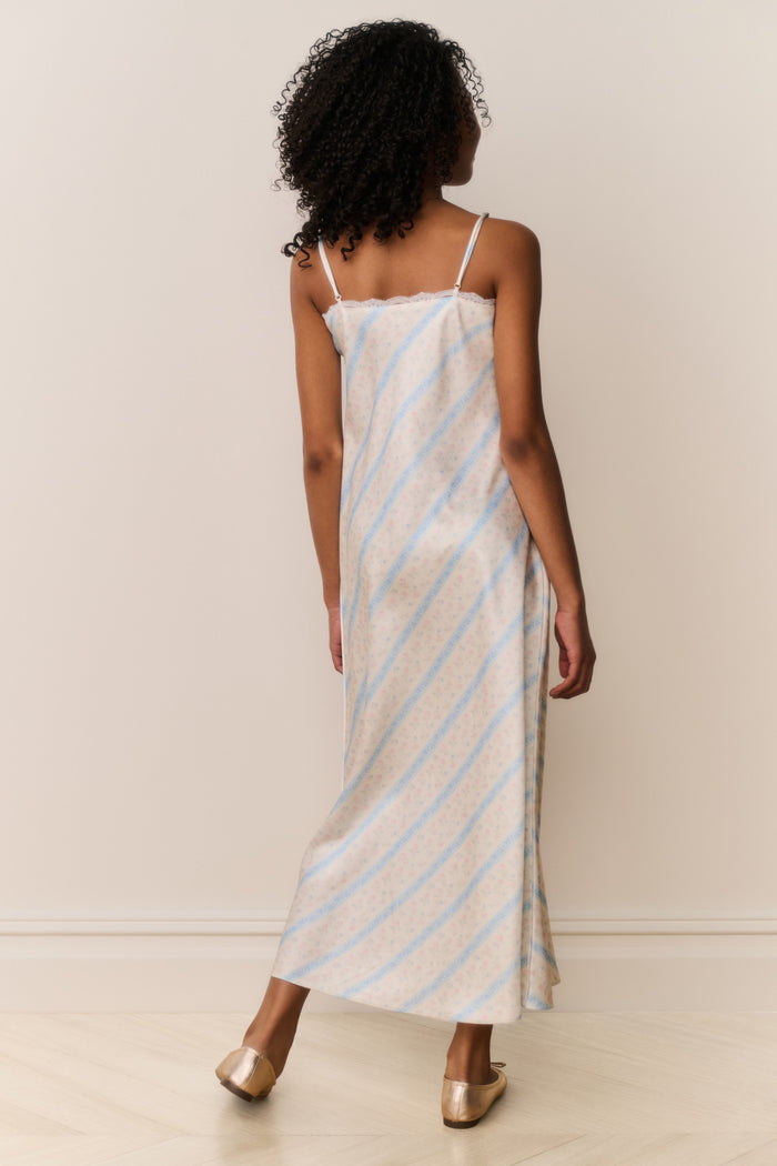Girl wears Striped slip dress with thin straps on beige background