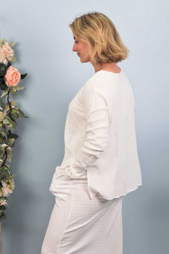 side profile of woman in white skirt and blouse