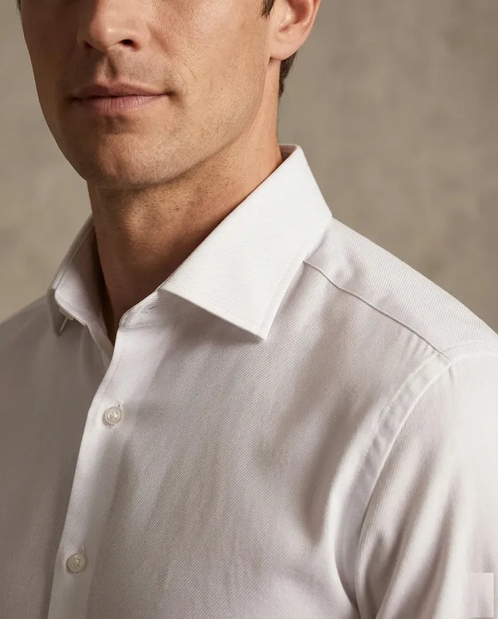 Man wearing a light gray dress shirt against a neutral background