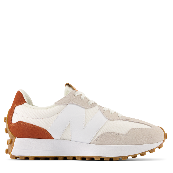 A women's running shoe with a white, beige, and orange color scheme, featuring a wedge silhouette and New Balance branding.