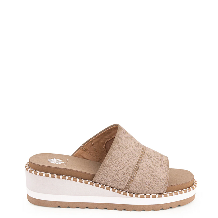 A woman's wedge sandal with a square toe and two-strap design in a neutral color, featuring a thick white wedge sole and a rubber outsole.